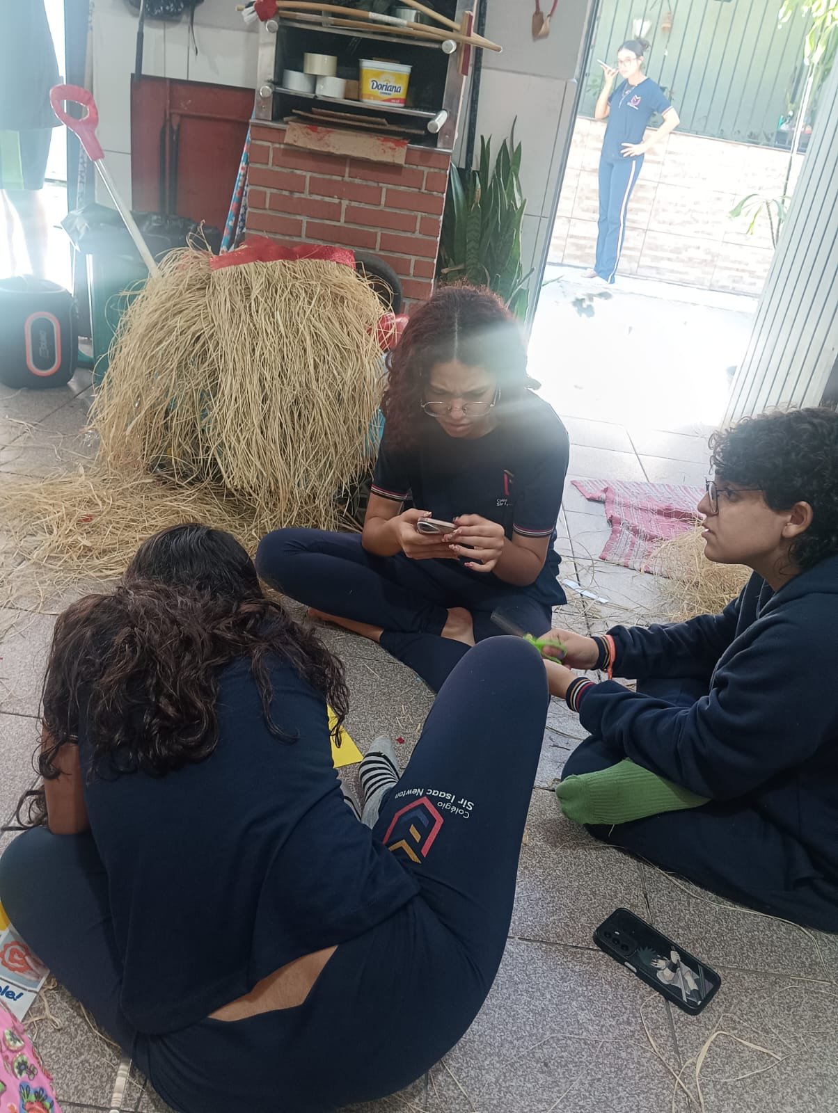 Alunos cortando palha no chão